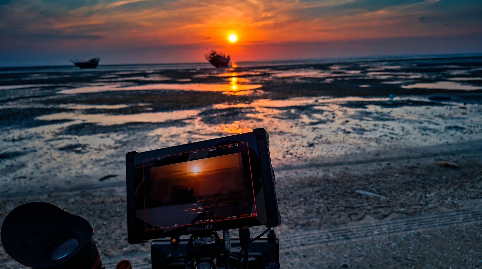 A monitor showing a sunset scene by the wetlands